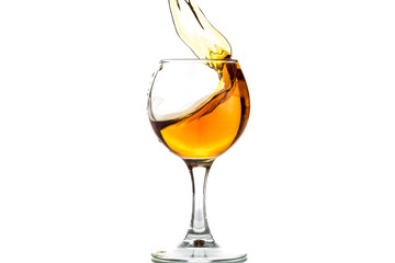 A round glass with brandy and a splash of drink inside