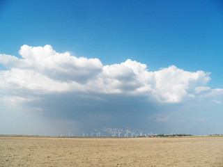Landscape with windmills on the background of the sky and the field. Wind turbines farm. sandy beach. wind power. ecology