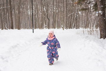 Family, children and nature concept - Beautiful little child girl have fun in winter park