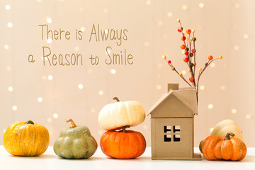 There is always a reason to smile message with collection of autumn pumpkins with a toy house