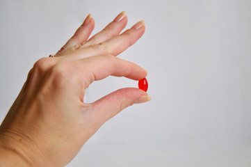 red medicine pill in a hand
