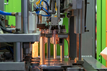 The  operation of  plastic bottle blowing process at the drinking factory. Drinking water container manufacturing process.