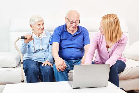 Sozialarbeiter zeigt Senioren Laptop Computer