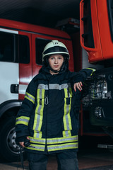 portrait of female firefighter in protective uniform with portable radio set at fire department
