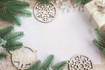 Christmas composition. Christmas gift, wooden snowflakes and figurines, pine cones, fir branches on wooden white ba