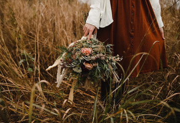 woman holding a harvest bouquet of fall flowers