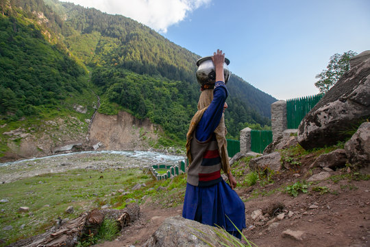 A Woman Carries Water Jug From River In Kashmir