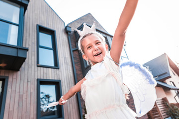 Beaming girl. Cute beaming little girl feeling simply amazing and cheerful while walking outside