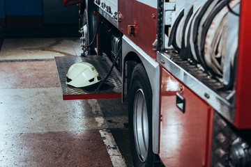 Naklejka premium close up view of protective helmet on fire truck at fire station