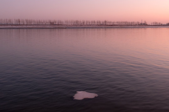 A patch of ice floats by a barren landscape near Sinuiju, North Korea seen across the Yalu River from Dandong, China.