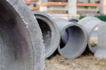 New concrete pipes (rings) are on the ground. IPart of a pipe with a bathing plan, in the...