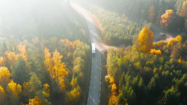 Delivery Truck Driving Through Autumn Forest, Aerial View
