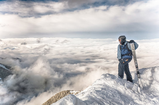 skier stay with skis on big rock on mountains backdrop. Bansko, Bulgaria