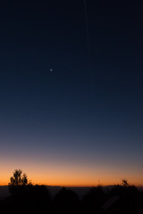 Sunrise in nature, with the moon shining in the sky