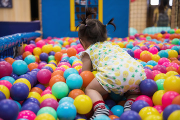 Fototapeta na wymiar little girl having fun in ball pool