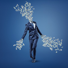 A businessman walks with his head and hands turned into money bills that fly away.