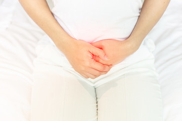 stomachache in young Asian woman  sitting on bed in bedroom after wake up,Healthcare concept