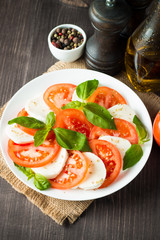 Close-up photo of caprese salad with ripe tomatoes, basil, buffalo mozzarella cheese. Italian and Mediterranean food concept. Fresh and healthy organic meal. Starter and antipasti. 