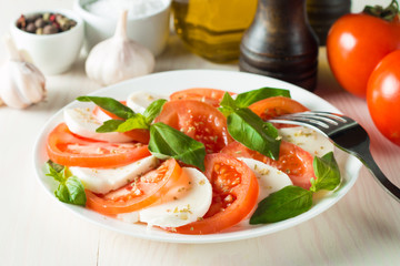 Close-up photo of caprese salad with ripe tomatoes, basil, buffalo mozzarella cheese. Italian and Mediterranean food concept. Fresh and healthy organic meal. Starter and antipasti. 