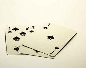 Three cards, seven and ace of peaks lie on a white background
