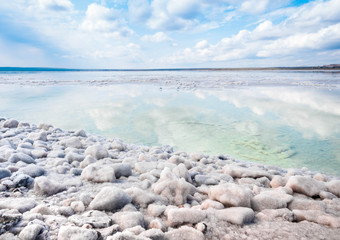 The stones are covered with a crust of salt on the shores of the salar Baskunchak. Extraction of...