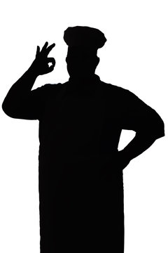 silhouette of a happy chef on a white isolated background, male hand shows ok