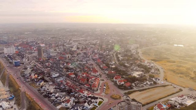 Quadcopter flight over the Zandvoort beach in the Netherlands. Morning sunrise over the city