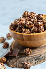 Caramel chocolate popcorn in a wooden bowl.