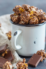 Chocolate popcorn in an enamel cup.