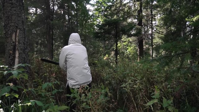 Man with machete in campaign through impassable areas of forest. Footage. Single journey in wild. Concept of man makes his way through difficulties and obstacles