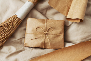 Craft paper parcel with decoration hemp threads on brown linen cloth textile.