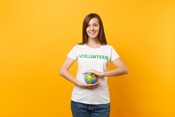 Portrait of woman in white t-shirt with written inscription green title volunteer hold in palms...