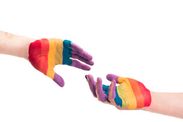 cropped image of gay couple reaching hands painted in colors of pride flag isolated on white, world aids day concept