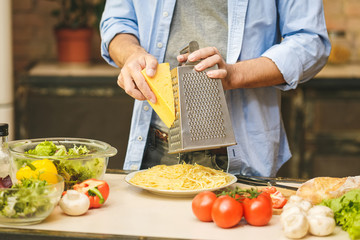 Man cooking healthy simple food at home in the kitchen sunny evening. Healthy food concept. Close-up.