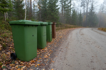 Fototapeta na wymiar four trash cans beside a gravel road near Nykroppa sweden