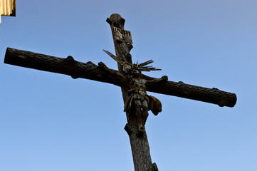 Large wooden sacred Christian religious Orthodox cross with crucified Jesus Hrit against a blue sky