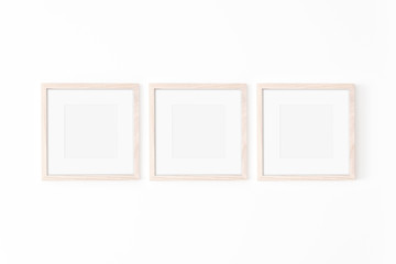 Set of 3 square Wooden frame mockup with passe-partout on white wall. Poster mockup. Clean, modern,...