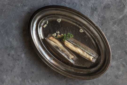Plate with garlic and razor clams