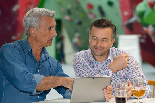 two businessmen chatting and having beer in bar
