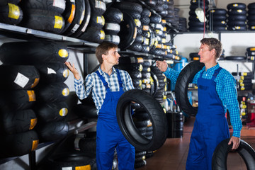 Two polite colleagues working with motorcycle tires