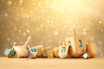 Banner of jewish holiday Hanukkah with wooden dreidels (spinning top) over glitter shiny background. © tomertu
