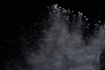 White powder explosion on black background. Dust splatted isolated. Paint Holi.