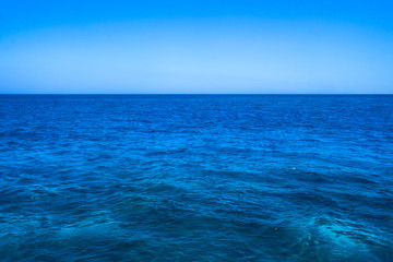 Obraz premium Beautiful blue sea surface with the sky. Oceanic deserted, lonely theme for background. Stock photo for tourist design