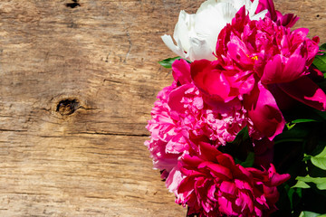 Naklejka na ściany i meble Beautiful peony flowers on rustic wooden background. Top view, copy space