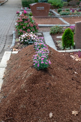 Frischer Grabhügel mit Blumen