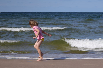 dziecko nad brzegiem morza, fale, zabawa z falami, Bałtyk