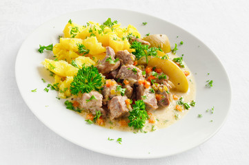 turkey stewed with apples, carrot, onion, and garlic garnished with potato and decorated with...