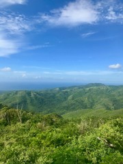 Fototapeta na wymiar Mirador Lookout Point Panorama View close to Trinidad (Sancti Spiritus) in the Cuban Countryside (Caribbean island) with an untouched lush green vegetation and a blue summer sky with white clouds