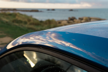 Reflection on the roof of a car during sunset, Brittany, France