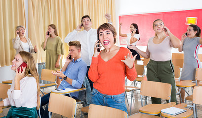 Student group talking on phones in classroom